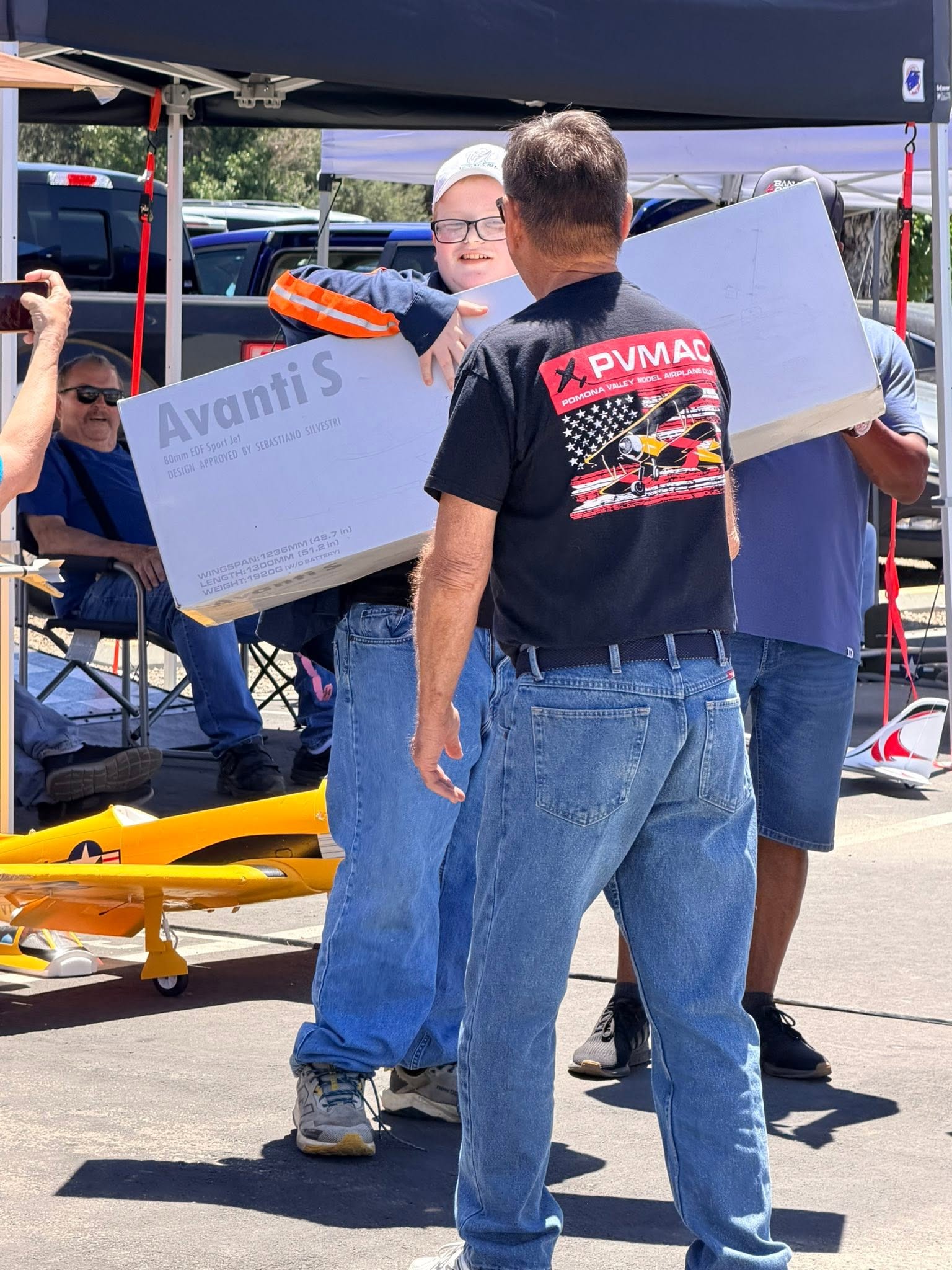 Smiling member holding an Avanti S RC jet box beside a pilot in a PVMAC logo shirt at Big Jolt